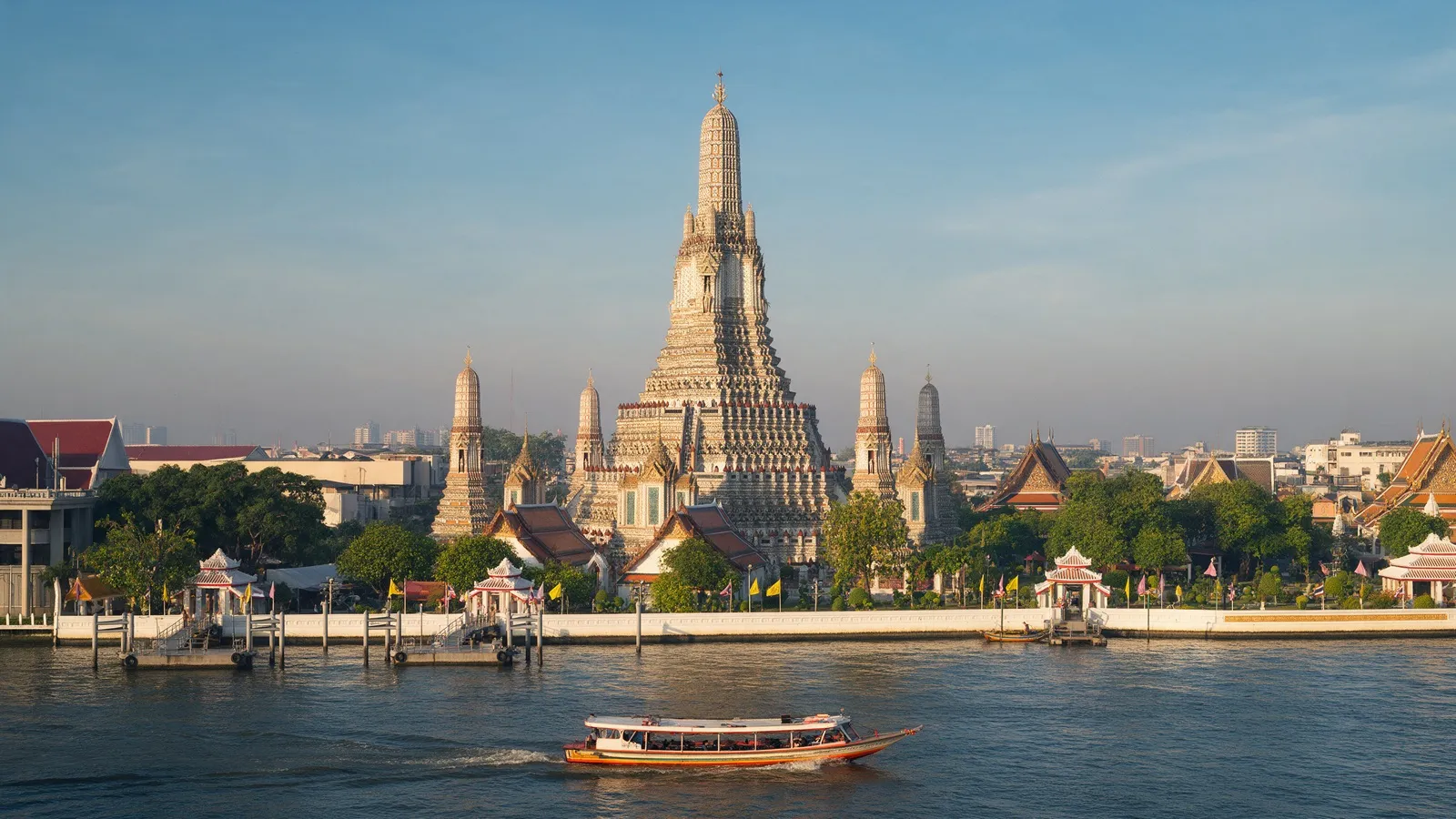 The main tower of Wat Arun, decorated with porcelain shards, on the Chao Phraya in the evening sun